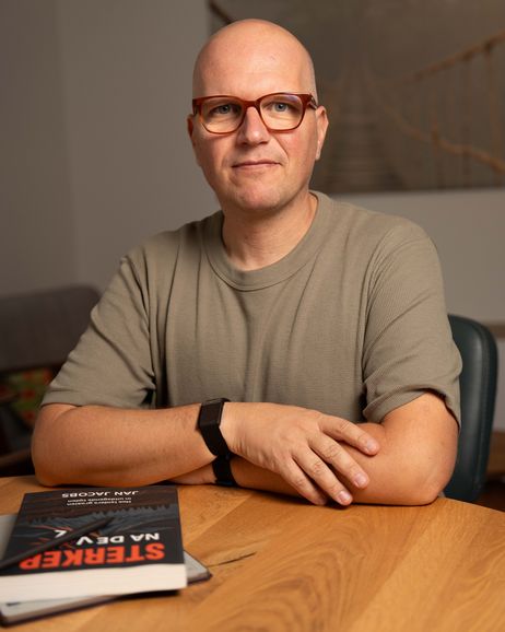 Jan Jacobs aan tafel, met Sterker na de val voor zich